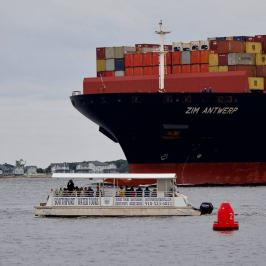 a large ship in front of the boat of Southport Water Tours