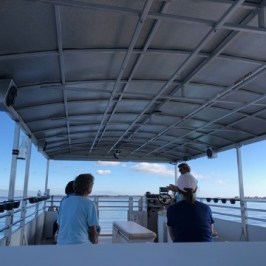 a group of people standing on boat of southport water tours