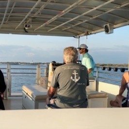 a group of people standing on a boat of southport water tours