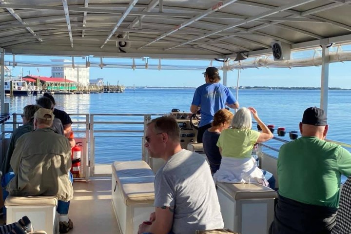 a group of people sitting on a boat of Southport Water Tours