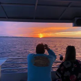 a man and woman sitting in front on a boat of Southport Water Tours