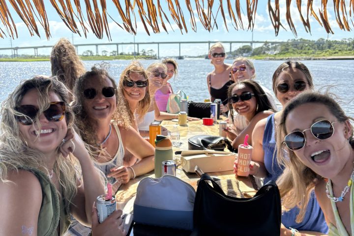 a group of people sitting at a table with a cake